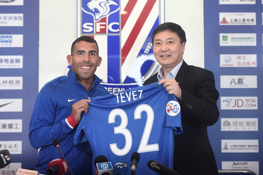 Carlitos Tevez posa con la maglia numero 32 e con Wu Xiaohui, presidente dello Shanghai Shenhua. Reuters